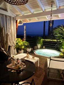 une terrasse avec une piscine la nuit dans l'établissement Indigo Palmes, à Sainte-Rose