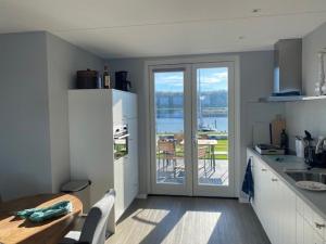 - une cuisine avec une table et une vue sur l'eau dans l'établissement Watervilla Den Oever VP066, à Wieringerwerf