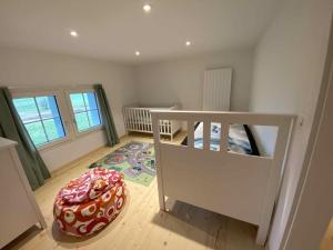 ein kleines Zimmer mit einem Kinderbett und einem großen Teppich in der Unterkunft Bauernhof Sal in Bütschwil