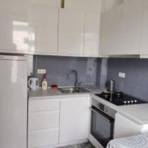 une cuisine avec des armoires blanches et un évier dans l'établissement Apartman na Bjelasnici- Srebrena lisica, à Bjelašnica