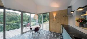 eine Küche mit einem Tisch und Stühlen sowie einen Balkon in der Unterkunft Kleines Vulkaneifelhaus in Schutz