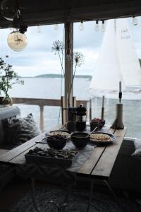 a wooden table with bowls of food on top of it at Archipelago Hideaway - Oasis on the Sea in Värmdö