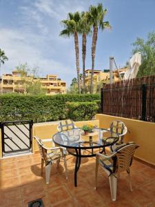een terras met een tafel, stoelen en palmbomen bij Yellowstone in Vera