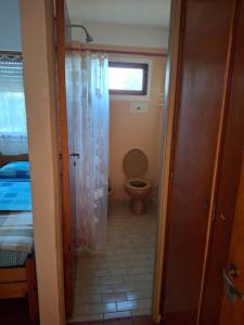 a small bathroom with a toilet and a window at hotel monte castello II in Villa Gesell