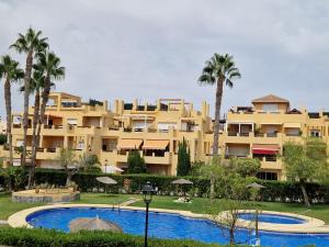 een groot gebouw met palmbomen en een zwembad bij Yellowstone in Vera