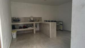a room with a kitchen with a counter and a microwave at Hotel Casa Del Angel in Chetumal