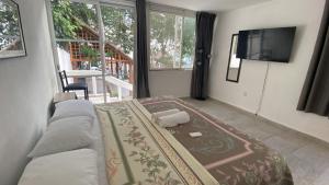 a living room with a couch and a flat screen tv at Hotel Casa Del Angel in Chetumal