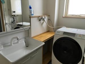 y baño con lavadora y lavamanos. en Ume, en Furano