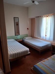 a bedroom with two beds and a mirror at hotel monte castello II in Villa Gesell
