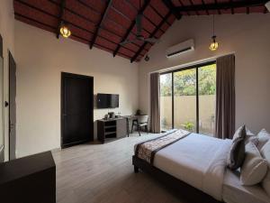 een slaapkamer met een bed, een bureau en een raam bij THE PREMIER GIR RESORT in Sasan Gir +88 foto's