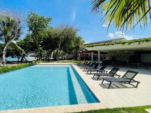 Puerto PlataMarien Residences 305 Deluxe High Floor Condo的建筑物旁边有躺椅的游泳池