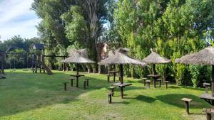 a park with tables and umbrellas and a playground at Los Curlis Dpto 2 Amb Las Gaviotas Mar Azul in Las Gaviotas