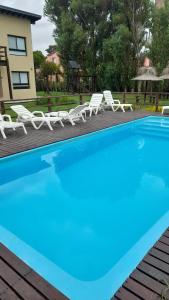a pool with lounge chairs and a house at Los Curlis Dpto 2 Amb Las Gaviotas Mar Azul in Las Gaviotas +9 photos