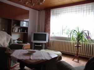 a living room with a table and a television and a window at Uns Oellernhuus in Ostseebad Karlshagen