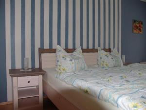 a bedroom with a bed and a night stand with a table at Uns Oellernhuus in Ostseebad Karlshagen