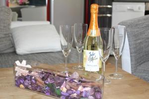 eine Flasche Champagner und vier Weingläser auf dem Tisch in der Unterkunft Ferienwohnung Vulkaneifel in Daun