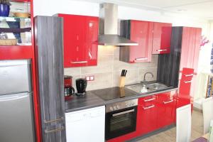 eine Küche mit roten Schränken und einer Spüle in der Unterkunft Ferienwohnung Vulkaneifel in Daun