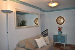 ein Wohnzimmer mit einer Couch und einem Spiegel in der Unterkunft Ferienhaus für 4 Personen ca 80 qm in Competa, Andalusien Costa del Sol in Cómpeta