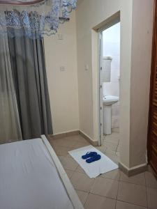 Un baño con una cama y toallas en el suelo. en Evara staycation, en Shanzu