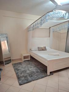1 dormitorio con 1 cama con dosel azul y blanco en Evara staycation, en Shanzu