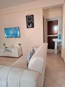 Una sala de estar con un sofá y un televisor. en Evara staycation, en Shanzu