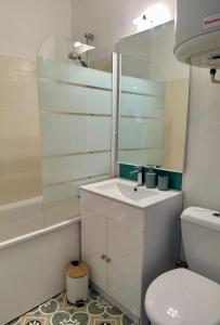une salle de bain avec un lavabo, des toilettes et un miroir dans l'établissement Appartement deux pièces élégant avec Vue sur Parc - Plage & Centre-Ville à Pied, à Cabourg