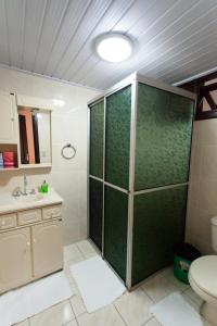 een badkamer met een douche, toilet en wastafel bij Casa Joseph in Gramado
