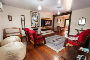 een woonkamer met rode stoelen en een open haard bij Casa Joseph in Gramado