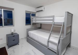 Ce lit superposé se trouve dans une chambre blanche avec une échelle. dans l'établissement Stay in my House Welcome to Ballardos Home, à Punta Cana 61 autres photos