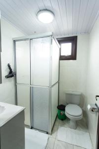 een badkamer met toilet en glazen douche bij Casa Joseph in Gramado +18 foto's