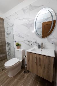 une salle de bain avec toilettes, lavabo et miroir dans l'établissement Stay in my House Welcome to Ballardos Home, à Punta Cana