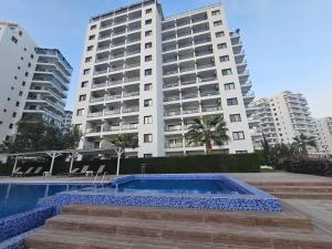 a swimming pool in front of two tall buildings at Caesar Resort Lux Studio Apt in Trikomo +14 photos