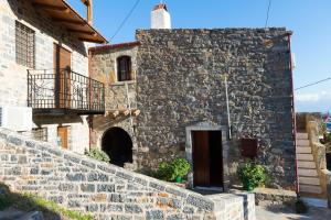 an old stone house with a stone wall at Leonidas Traditionelles Kretisches Haus Mit Meerblick in Elounda +24 photos