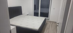 ein kleines Bett in einem Zimmer mit Fenster in der Unterkunft Locker in Prizren