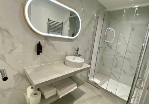 a bathroom with a sink and a shower and a mirror at RIOSHOUSE Henley in Henley on Thames
