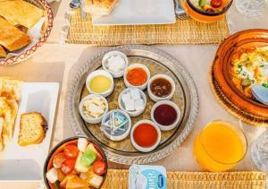a table with plates and bowls of food on it at Sahara Nights Luxury Camp in Merzouga +28 photos