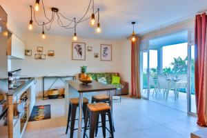 a kitchen and living room with a table and chairs at Blue Horizon - La Jungle Moana Suite - Vue Mer in Papeete