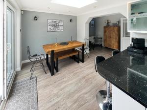 a dining room with a wooden table and chairs at The Miners House in Deal