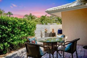 een patio met een glazen tafel en stoelen bij Siesta Villa Whispering Palms in Siesta Key