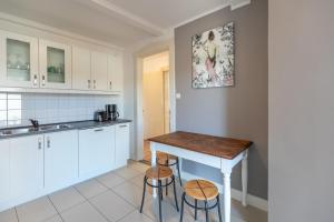 eine Küche mit weißen Schränken, einem Tisch und Stühlen in der Unterkunft Neustadt Domizil in Husum