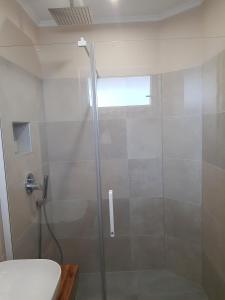 une douche avec une porte vitrée dans une salle de bain dans l'établissement Ferienhaus Mit Privatem Pool In Ruhiger Lage, à Kaštel