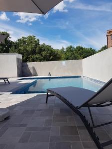 une chaise assise à côté d'une piscine dans l'établissement Ferienhaus Mit Privatem Pool In Ruhiger Lage, à Kaštel