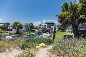 een huis met een zwembad en een palmboom bij Marysol Main in Edisto Beach