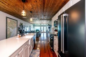 een keuken met een zwarte koelkast en houten plafonds bij Marysol Main in Edisto Beach