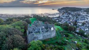 - un vieux château sur une colline à côté de l'océan dans l'établissement Gower Group Getaway Sleeps 14, à Mumbles