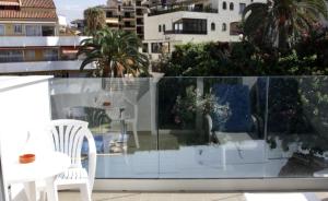 a balcony with a white table and chairs on a balcony at Estudio con Piscina en Puerto de la Cruz in Puerto de la Cruz
