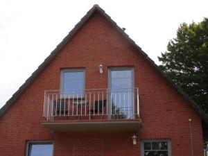 a red brick building with a balcony with a dog on it at Ferienhaus In Winnemark Mit Großem Garten in Winnemark