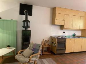 a kitchen with a stove and a chair in a room at Chesa Muntanaia in Pontresina