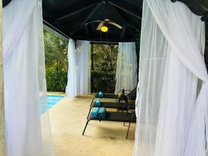 a room with white curtains and a couch and a pool at Casa Verapaz in Santa Catarina Palopó