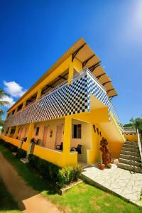 ein gelbes Haus mit blau-weiß in der Unterkunft Fonte dos Corais - Suíte Lua na Praia in Maragogi